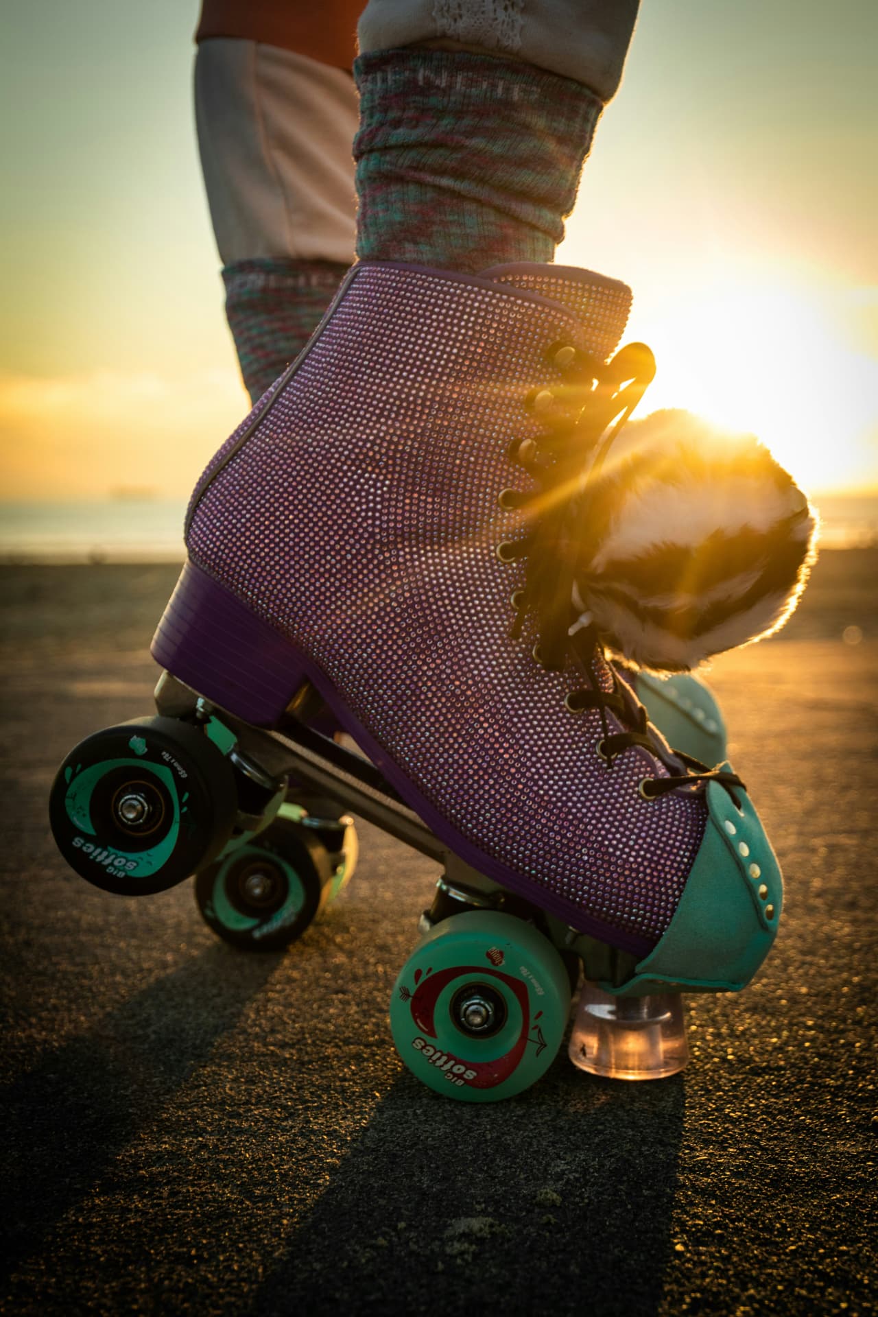 Close-up of a purple roller skate on tarmac at golden hour