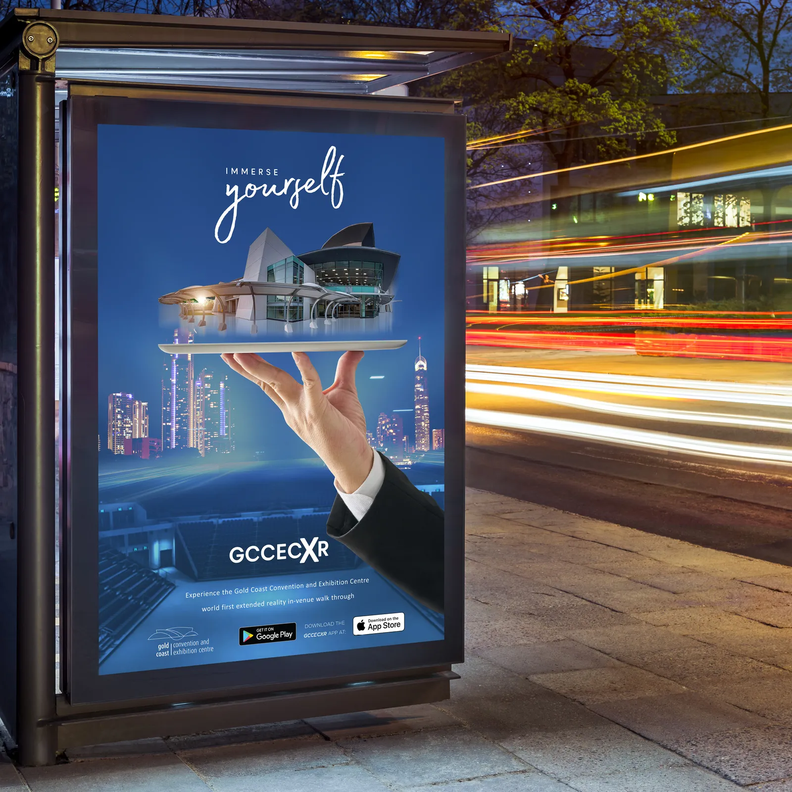 GCCEC XR Immerse Yourself bus shelter advertisement at night showing the exhibition centre balanced on a tray