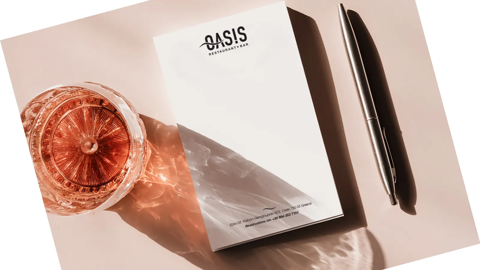 Oasis letterhead with a glass of rosé and a pen